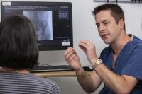 Physician explains procedure to female patient.